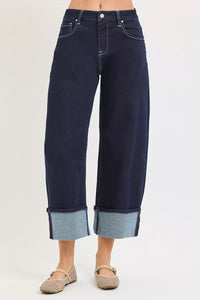 Dark blue jeans with rolled-up cuffs on a white background
