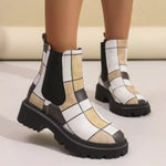 Checkered patterned boots worn by a person on a neutral background