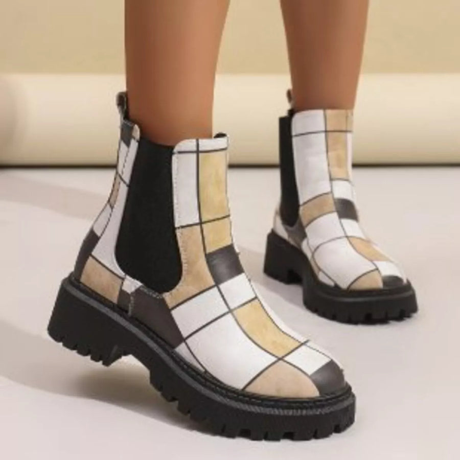 Checkered patterned boots worn by a person on a neutral background