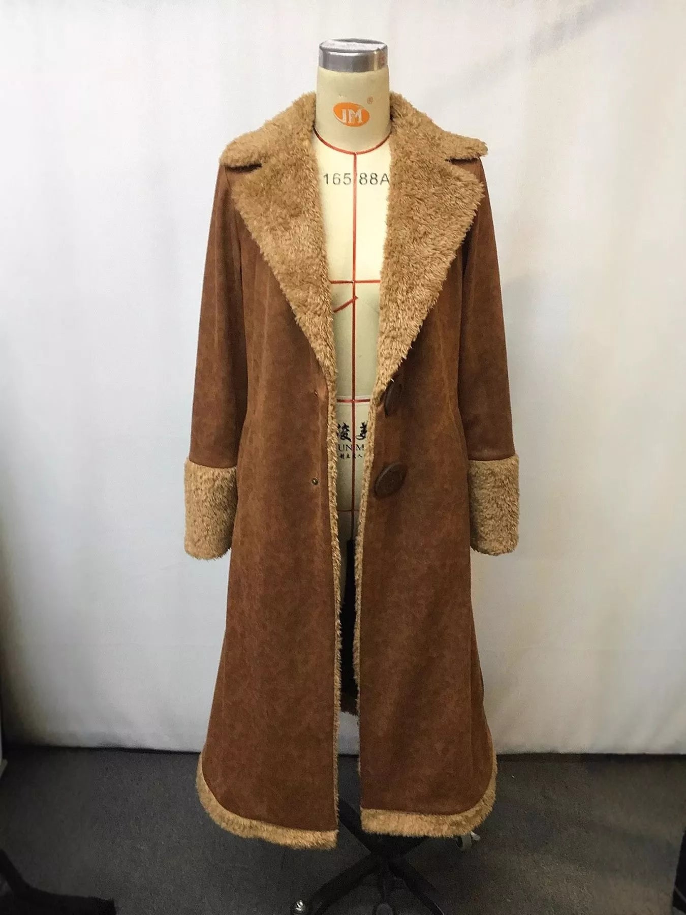 Brown coat with fur trim on a mannequin against a white background