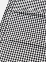 A close-up of a black and white gingham check fabric with a visible fold.