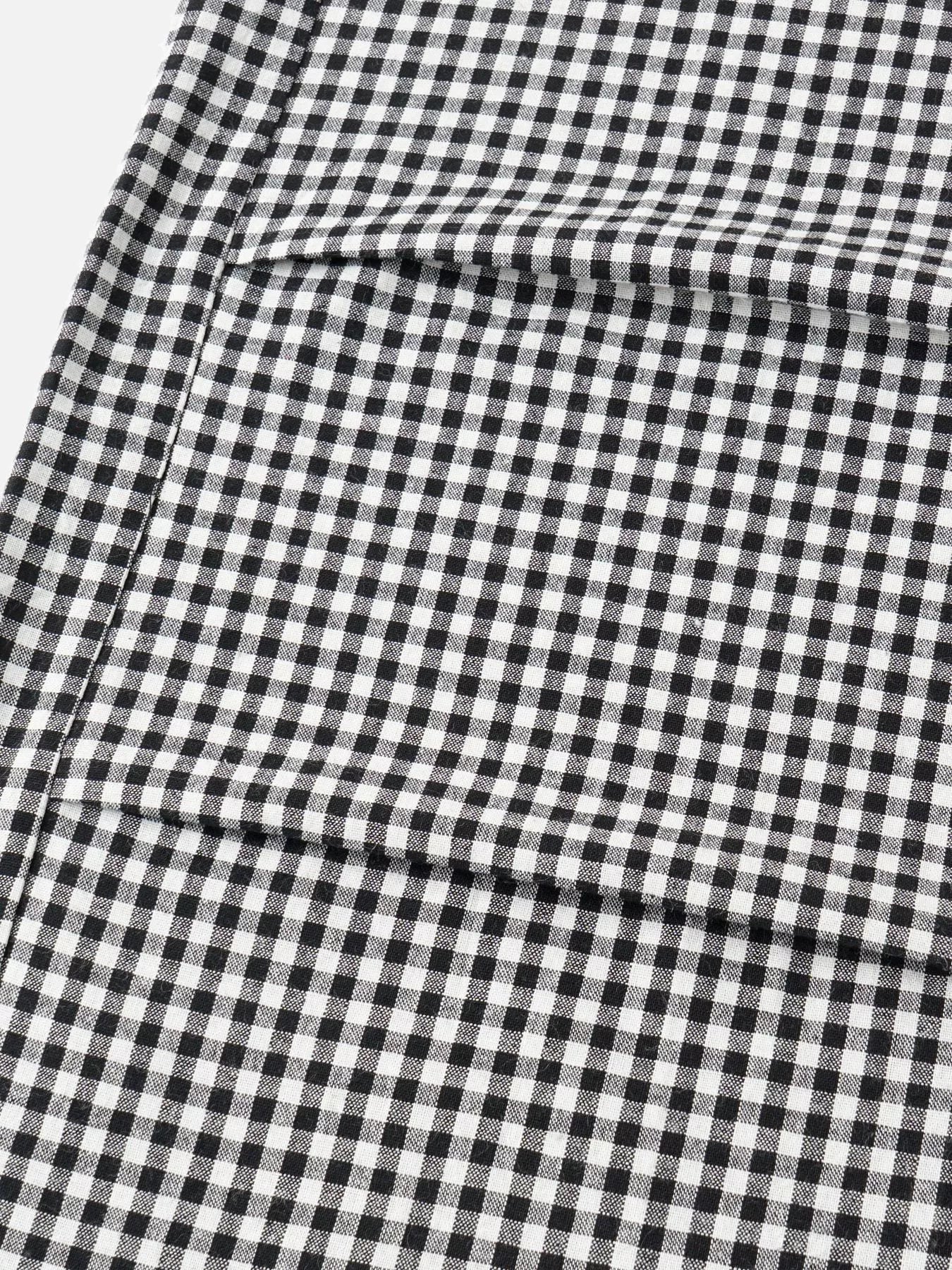 A close-up of a black and white gingham check fabric with a visible fold.