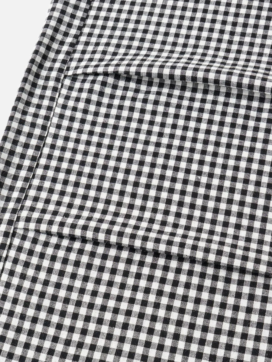 A close-up of a black and white gingham check fabric with a visible fold.