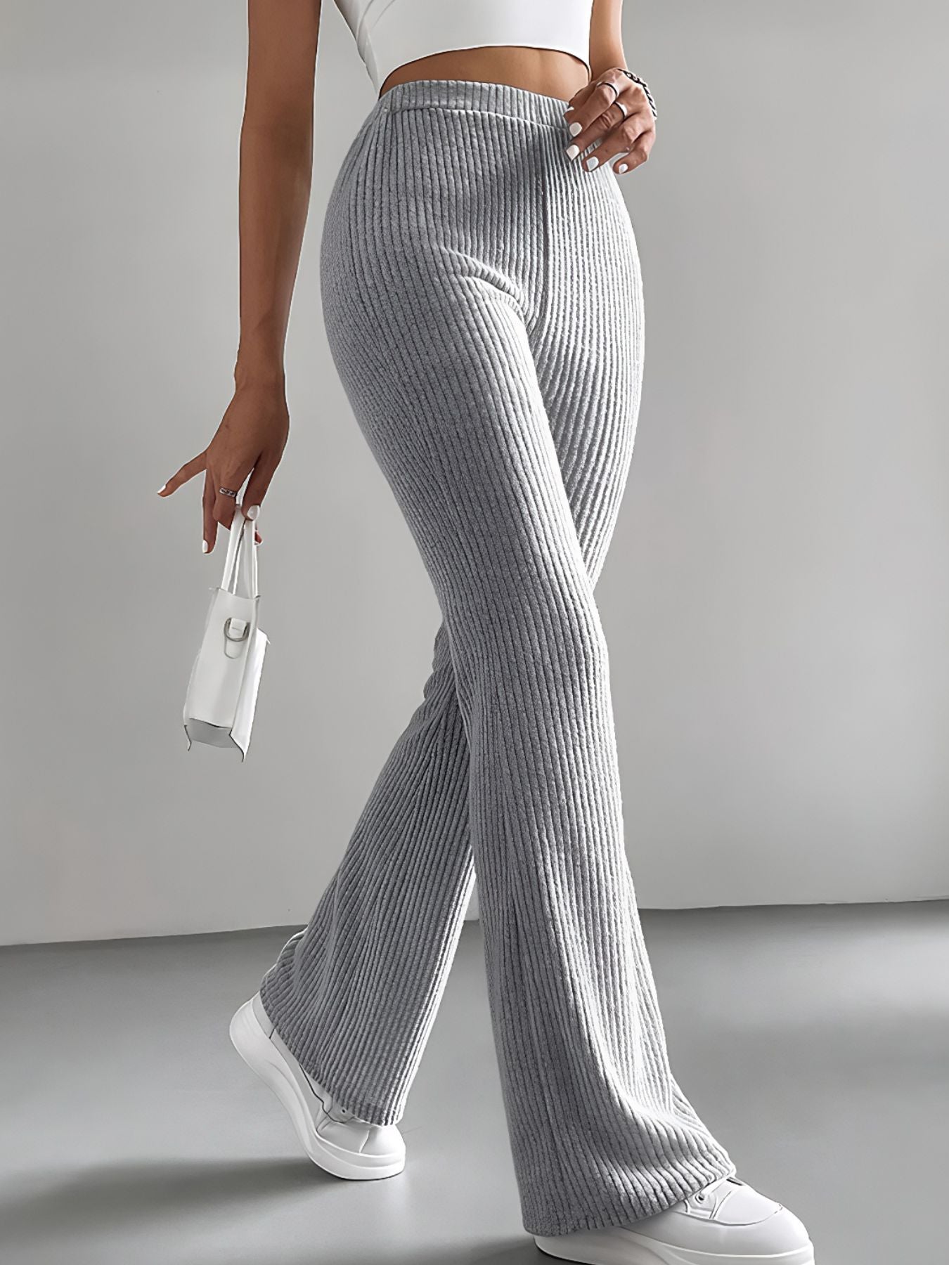 Person wearing gray ribbed pants with a white background