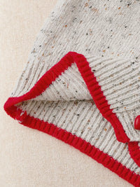 Close-up of a textured fabric with red trim on a beige background