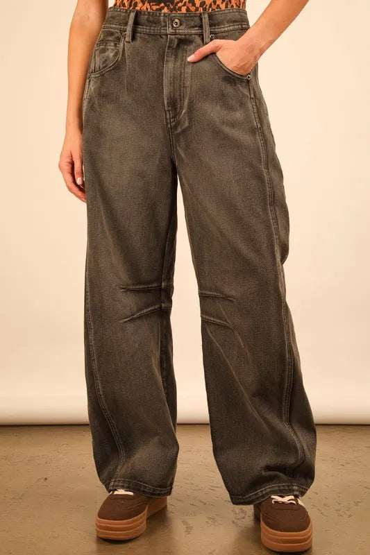 Person wearing wide-leg jeans with a plain background