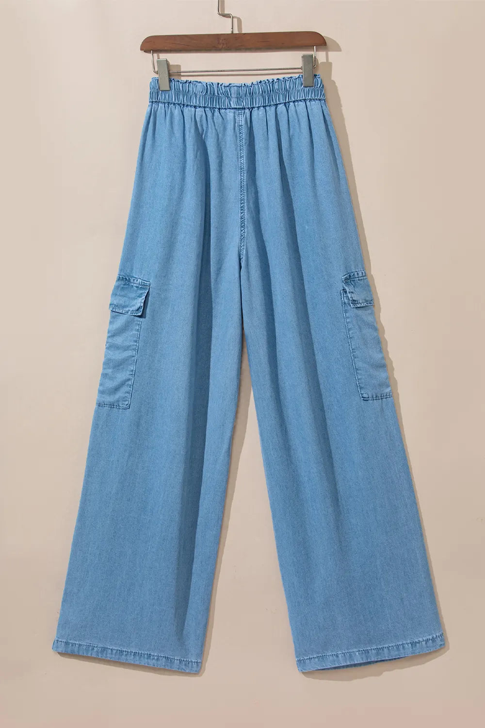 Blue denim cargo pants on a beige background