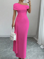 Woman wearing a bright pink off-shoulder dress holding a white handbag indoors.