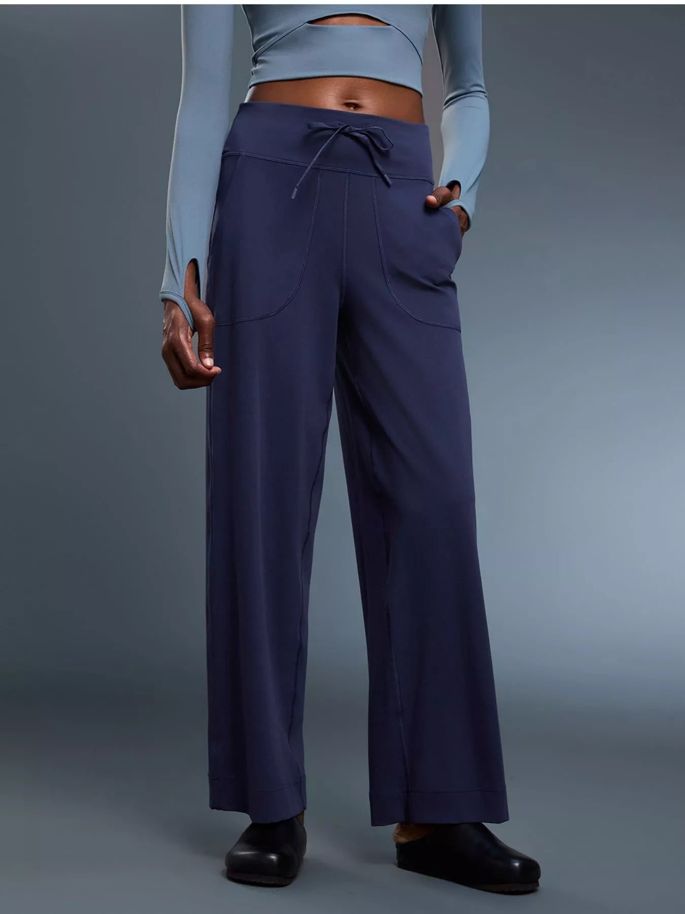 Person wearing navy blue pants on a gray background