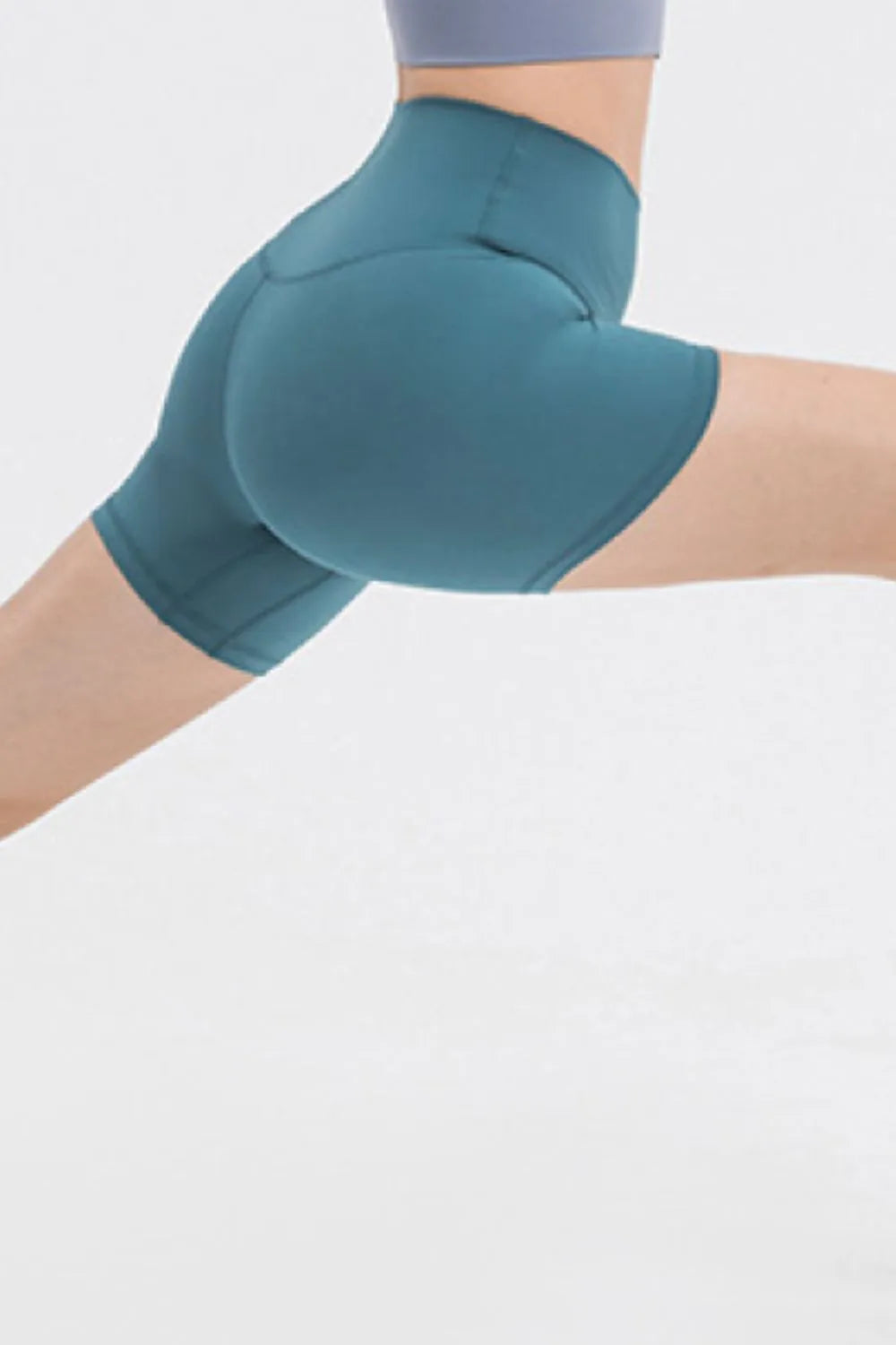 Teal athletic shorts worn by a person on a light gray background