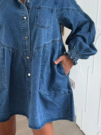 Blue denim dress worn by a person with a white wall background