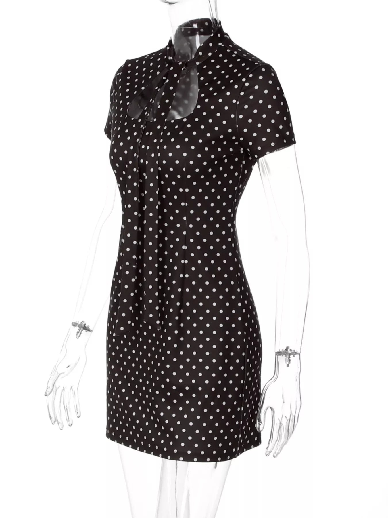 Black dress with white polka dots on a mannequin against a white background
