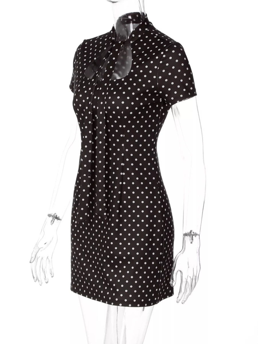 Black dress with white polka dots on a mannequin against a white background