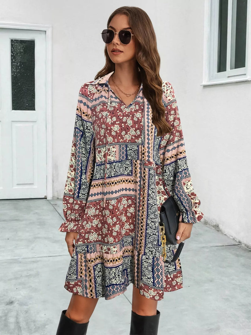 Woman wearing a patterned dress with long sleeves in an outdoor setting.