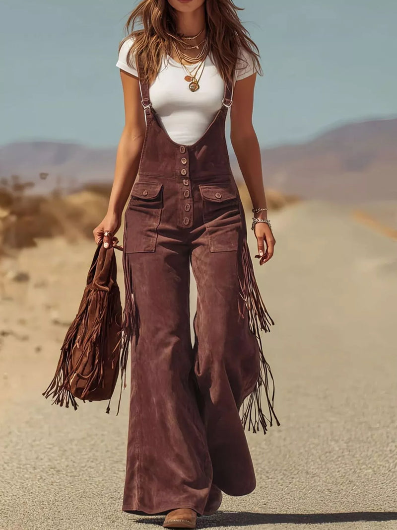 Woman in brown fringed overalls standing in a desert landscape