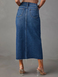 Person wearing a blue denim skirt on a gray background