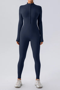 Person wearing a navy blue full-body suit on a light gray background