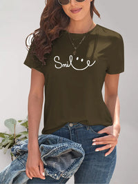 Woman wearing a brown t-shirt with 'Smile' text, holding a denim jacket.