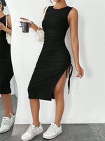 Woman wearing a black sleeveless dress with a side slit, standing against a white background.
