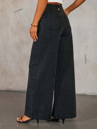 Person wearing wide-leg black jeans against a plain background