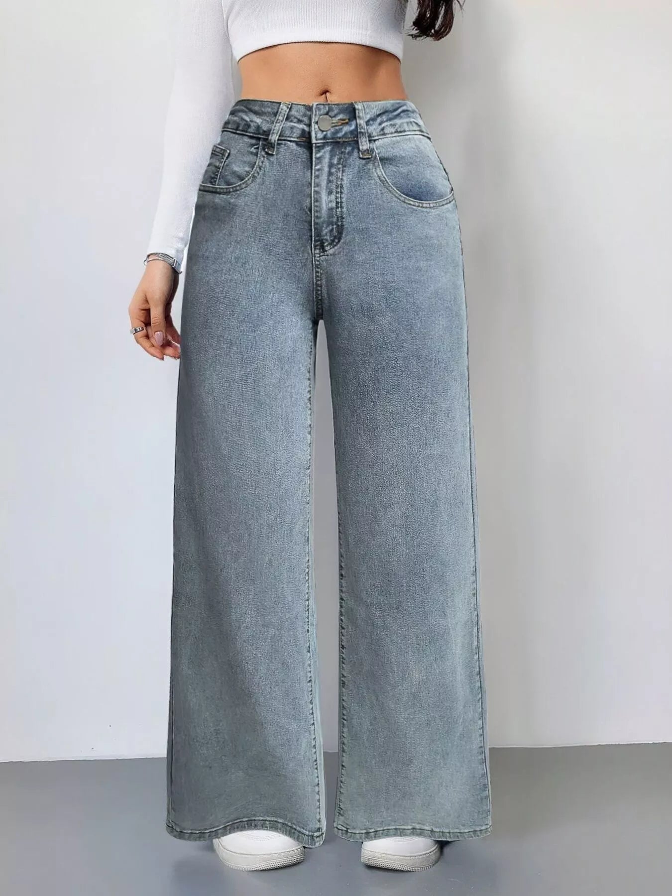 Wide-leg jeans worn by a person on a plain background