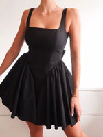 Black dress worn by a person on a plain background
