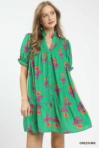 Woman wearing a green dress with floral patterns on a white background