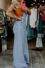 Person wearing a denim dress in a clothing store.