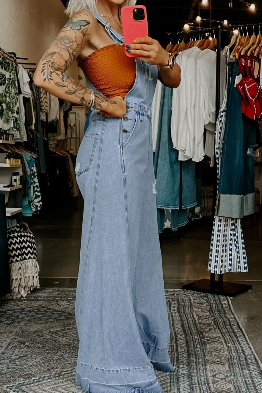Person wearing a denim dress in a clothing store.