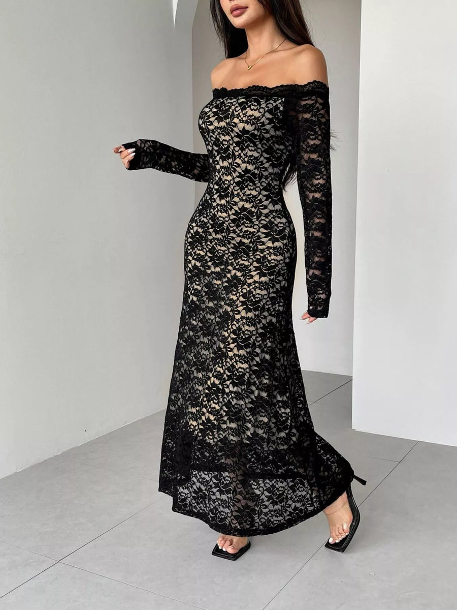 Woman wearing a black lace off-shoulder dress against a white background