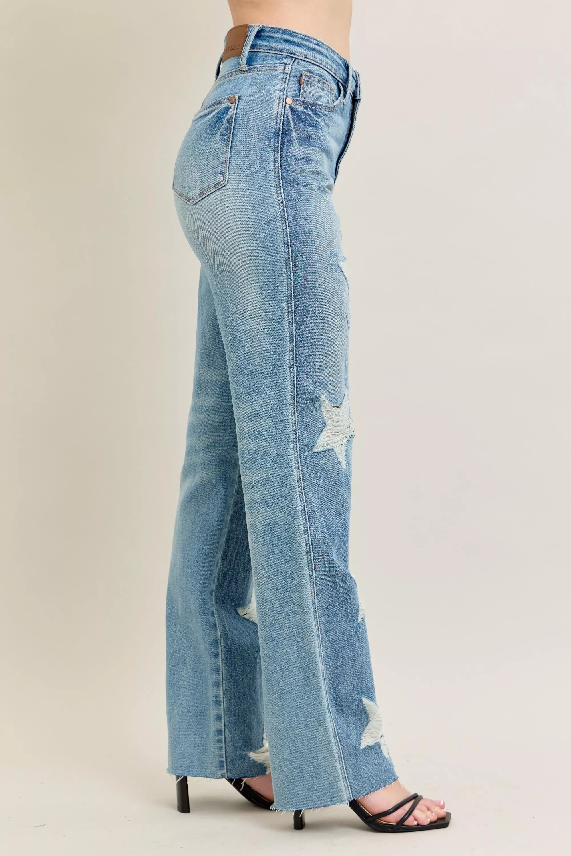 Light blue jeans with a star design on a beige background
