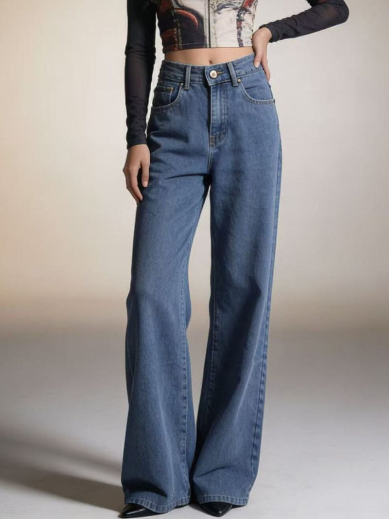 Person wearing blue flared jeans on a plain background