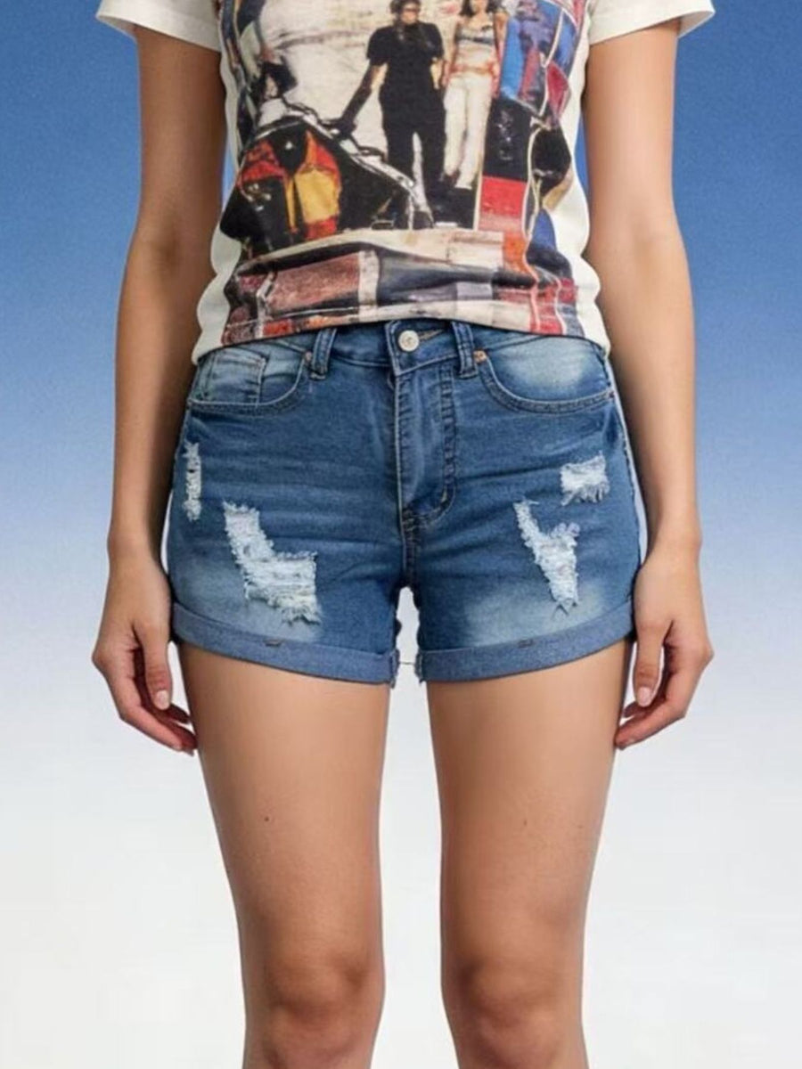 Person wearing a graphic t-shirt and distressed denim shorts on a blue and white gradient background