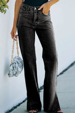 Person wearing black flared jeans with a blurred background