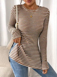 Person wearing a brown and beige striped long-sleeve top with blue jeans against a neutral background