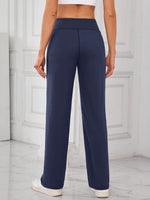 Navy blue pants worn by a person in a minimalistic setting