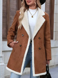 Woman wearing a brown shearling coat with white lining, standing outdoors.