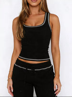 Person wearing a black tank top with white trim on a white background