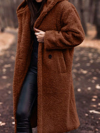 Person wearing a brown teddy coat in a forest setting