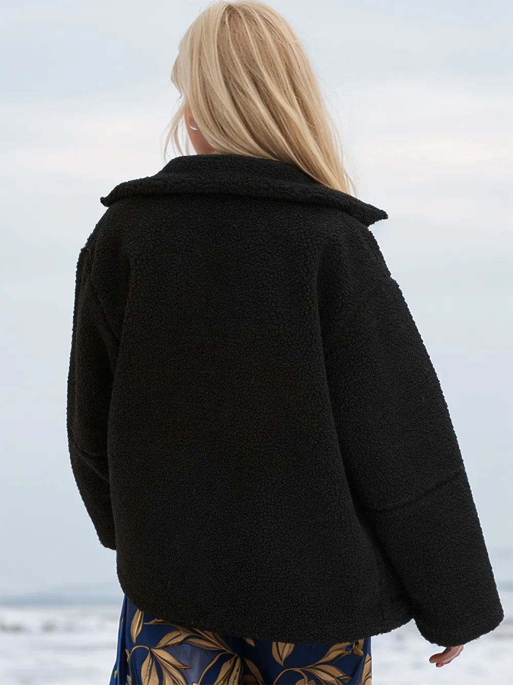 Person wearing a black coat with a blurred background