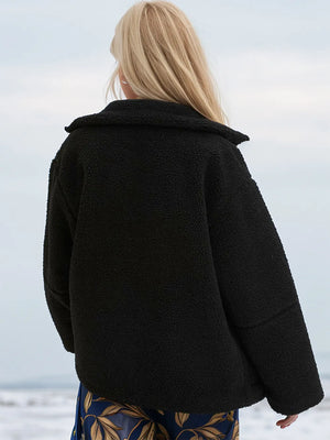 Person wearing a black coat with a blurred background