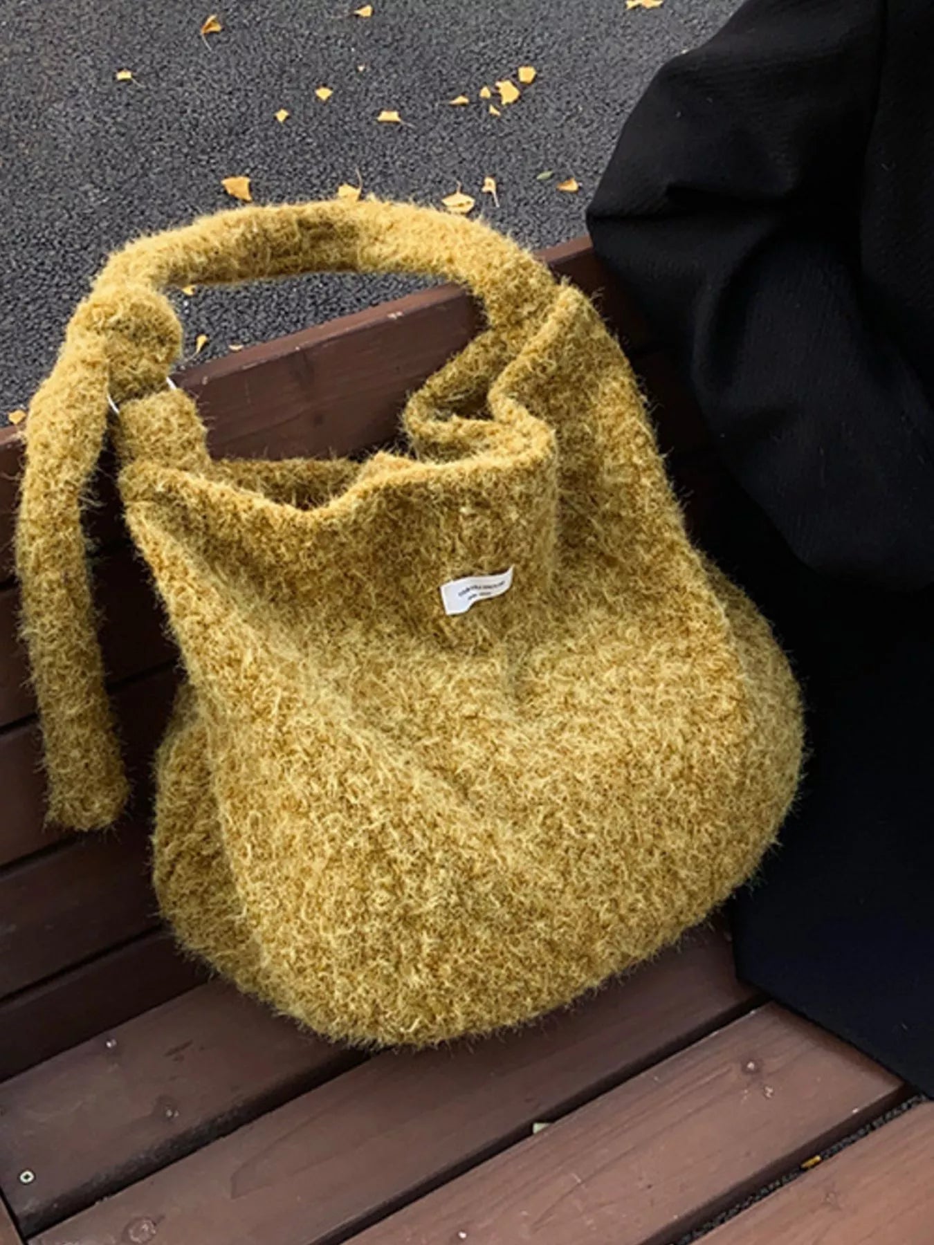 Yellow fluffy bag on a wooden bench with a dark background