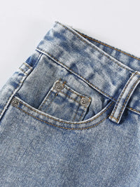 Close-up of a blue denim pocket with stitching details on a light gray background