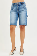 Denim shorts worn by a person on a white background