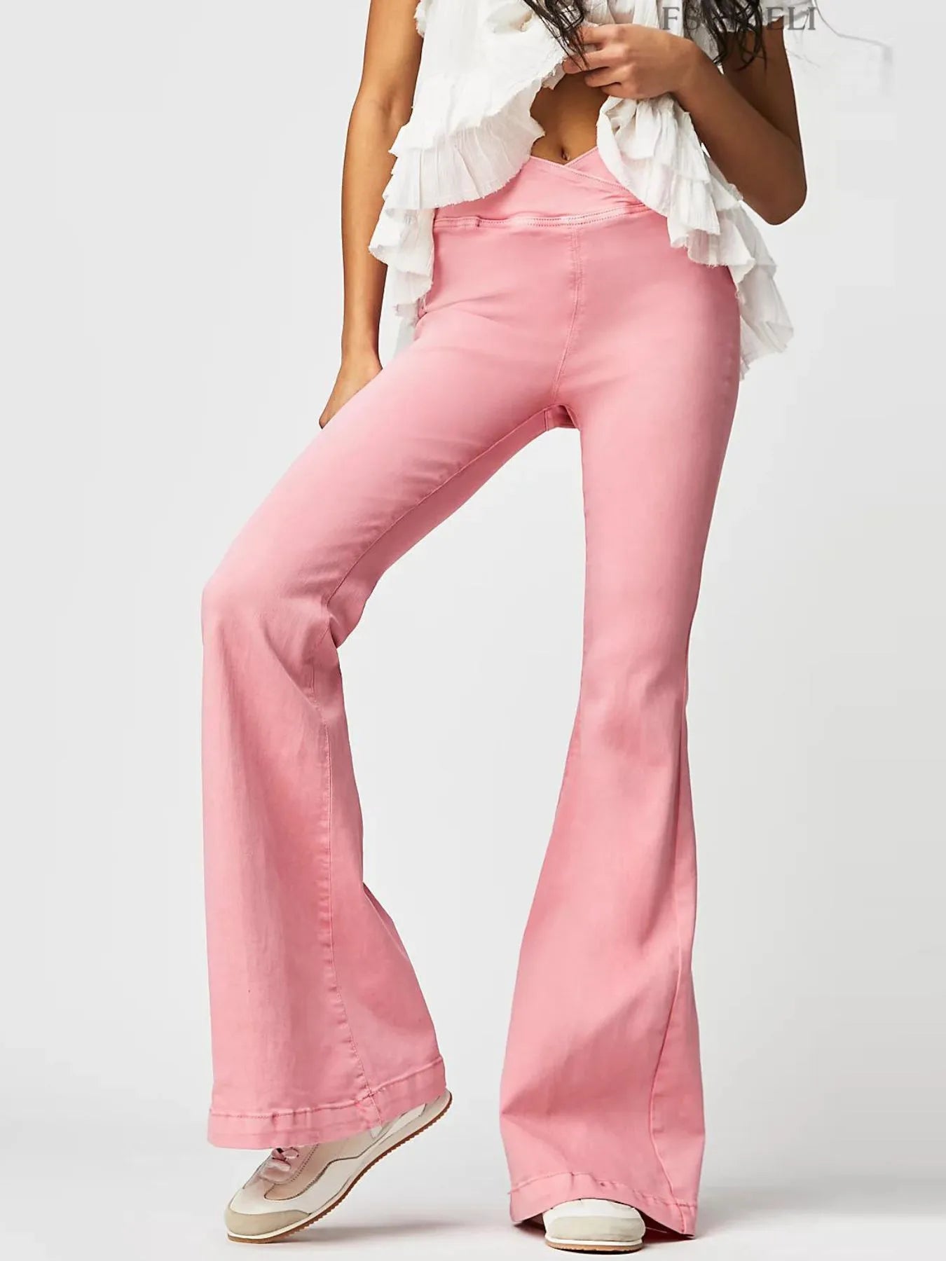 Pink flared jeans worn by a person on a white background