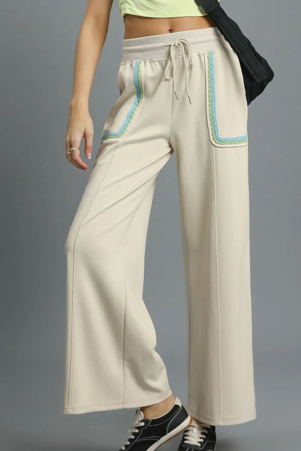Beige wide-leg pants with blue accents on a gray background