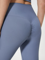 Blue leggings worn by a person on a light gray background