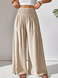Beige wide-leg pants worn by a person on a white background