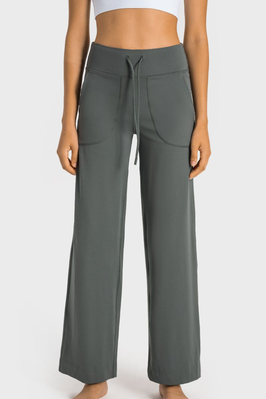 Person wearing gray wide-leg pants on a white background