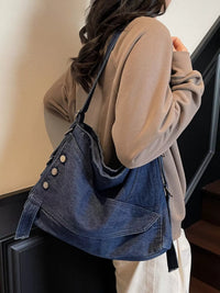 Person wearing a beige coat with a blue denim bag over their shoulder.